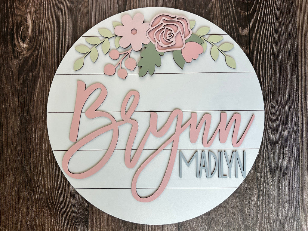 Baby name sign with pink flowers.