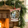 Personalized Christmas ornament with a dog's photo on a fireplace mantel decorated with greenery.