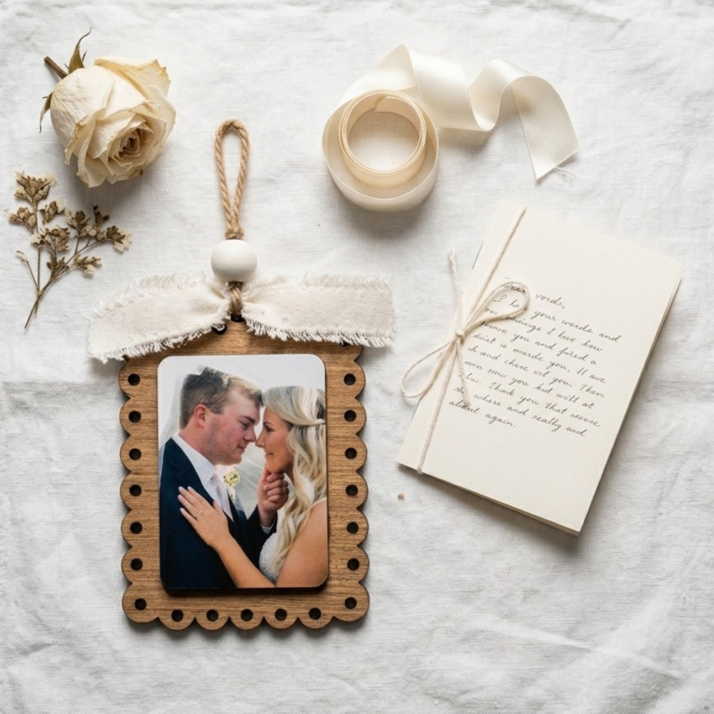 Decorative photo frame with a couple's photo, flowers, and ribbon on a textured surface