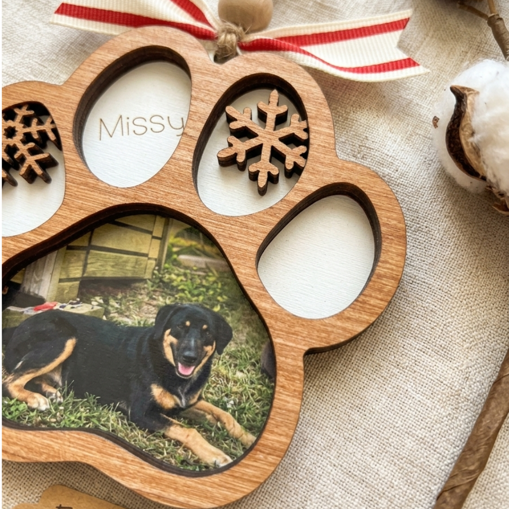 Wooden paw-shaped photo frame with a dog photo and 'Missy' text, on a textured surface.