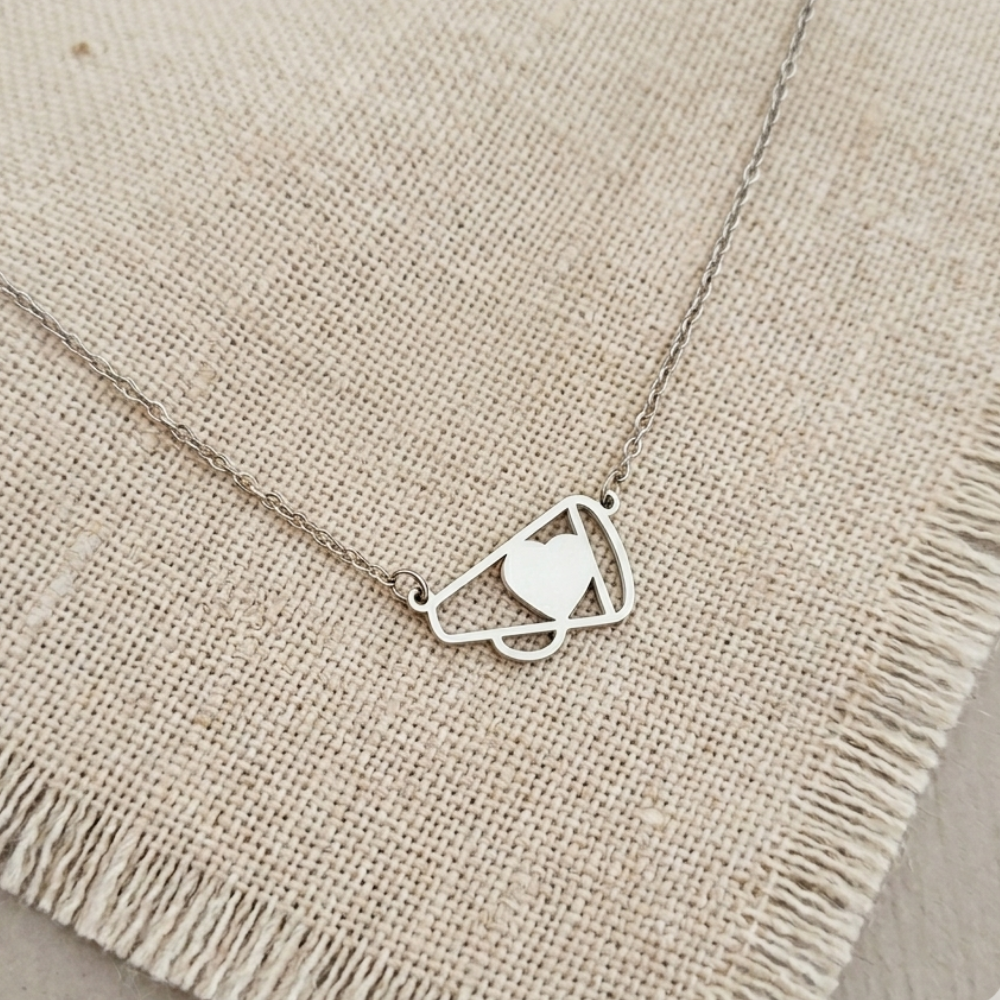 Silver necklace with a heart pendant on a beige fabric background