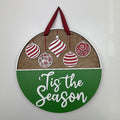 Tis the season door sign showing ornaments hanging.